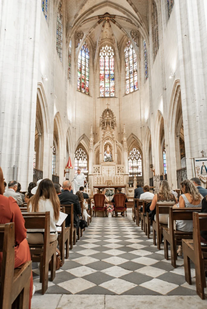 Photo des mariées dans l'église entouré des invités lors de la cérémonie, photo prise par Quentin Viel